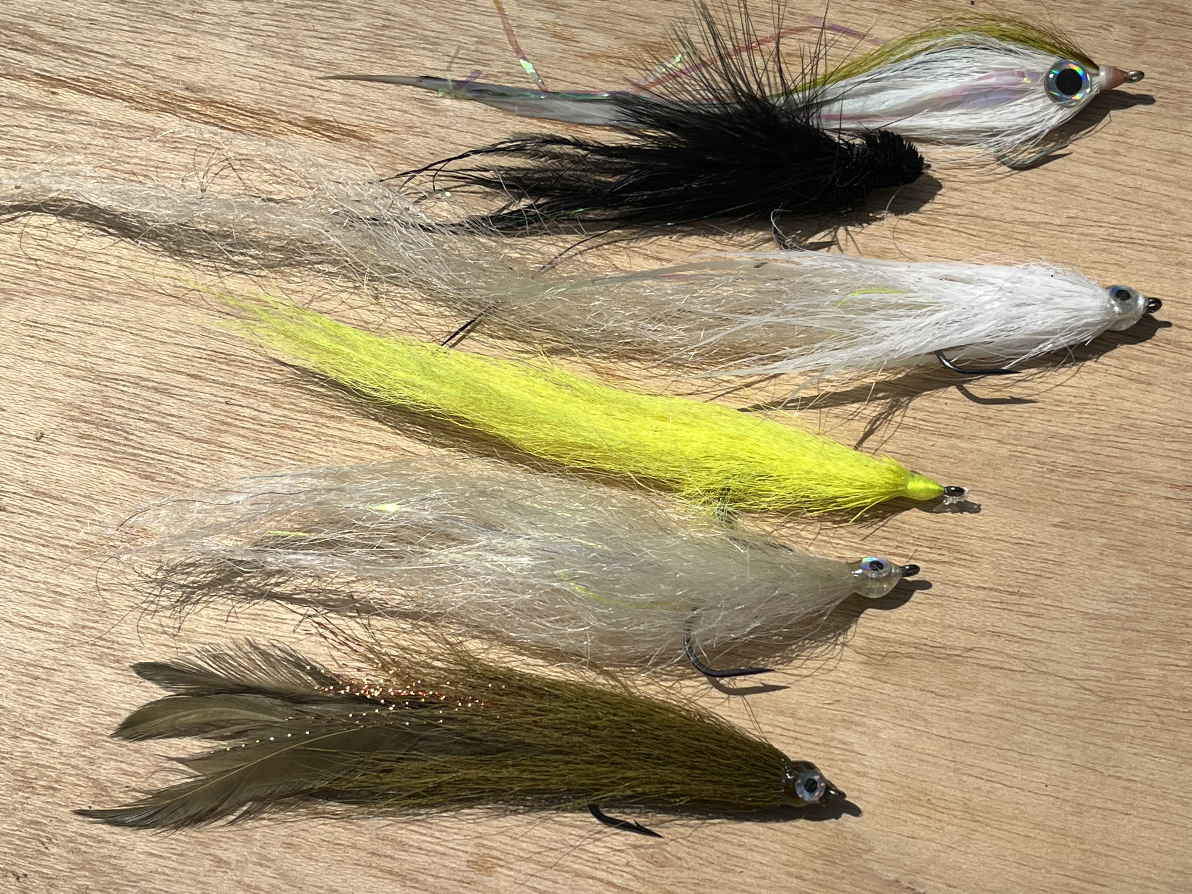 Bucktail fibers, yak hair, and chicken feathers make up the early season striper offerings.