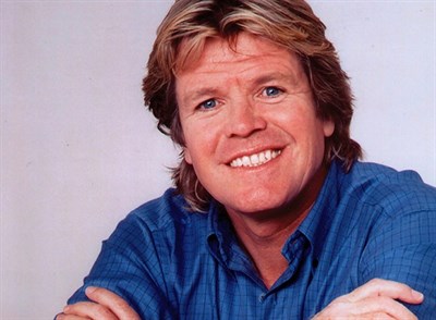 Peter Noone wearing a blue shirt and smiling Photo