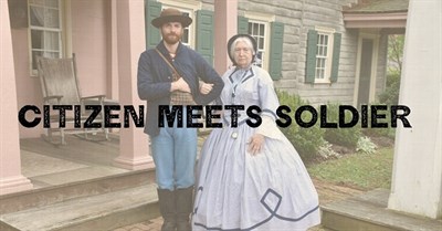 A woman in 1860s dress stands beside a U.S. soldier. Photo