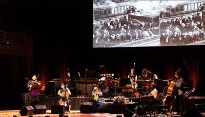 Silkroad Ensemble American Railroad orchestra performance in front of screen. Photo