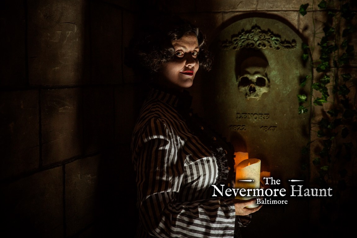 Victorian woman in the dark holding a candle in front a tomb Photo
