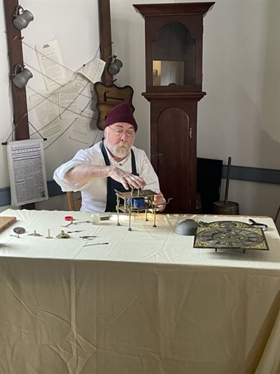 A Clockmaker balancing gears Photo