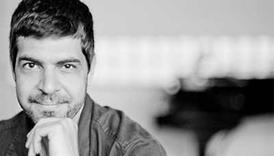 Andre Meharmi gazing into the camera with one hand on his chin. Photo