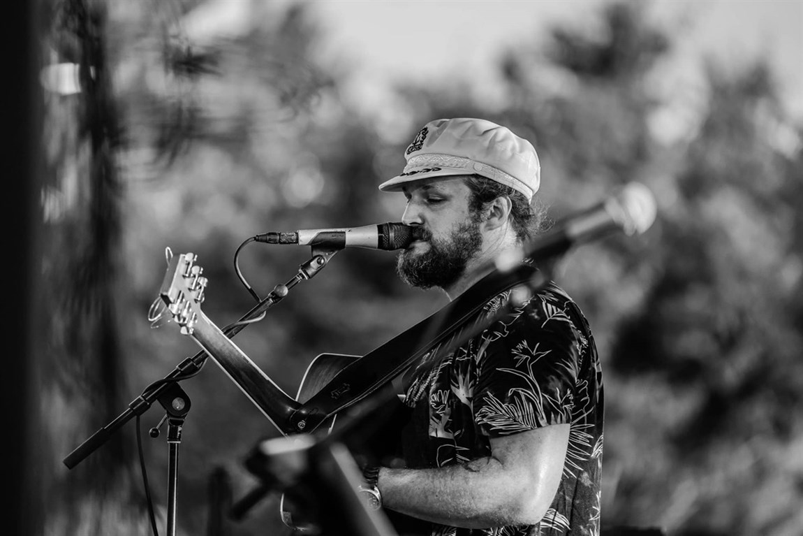 Captain Mike singing with a guitar Photo