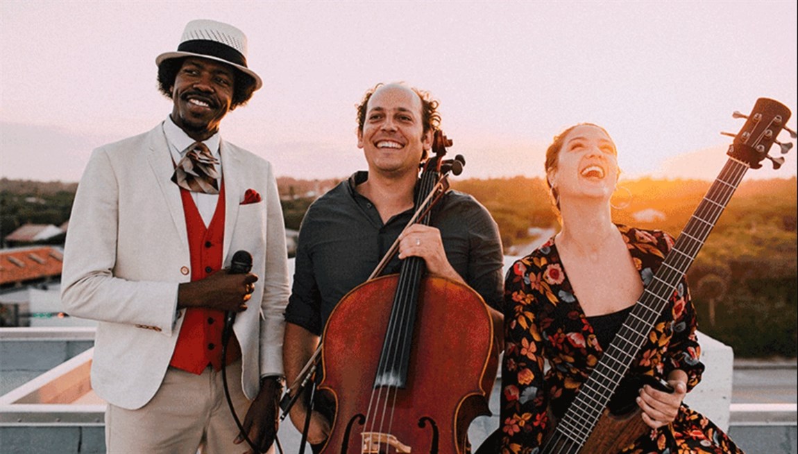 Biribá Union band members with instruments, standing on top of a roof during sunset. Photo