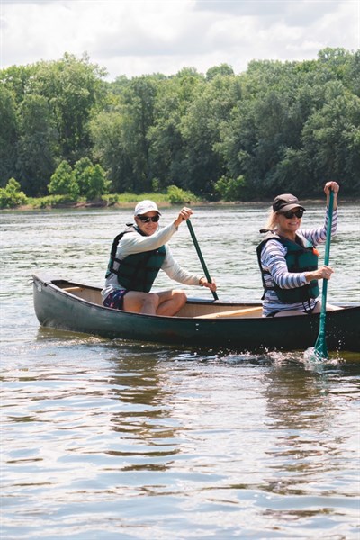 Two people in a canoe, paddling on the Potomac River.  Photo