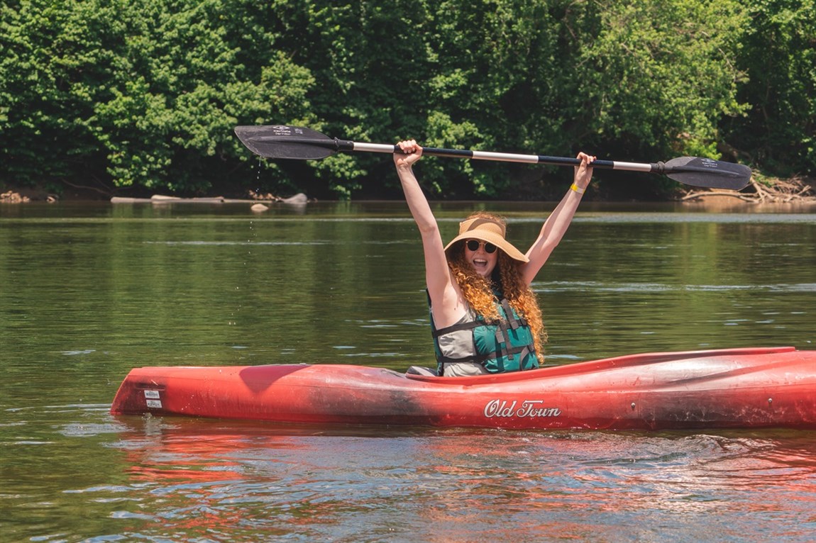 Person in kayak with an excited look on her face.  Photo
