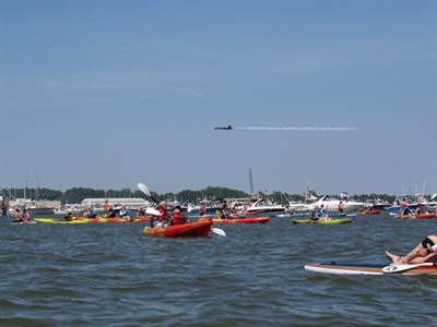 A kayaker on the Chesapeake Bay watches as a U.S. Navy Blue Angels jet flies overhead. Photo