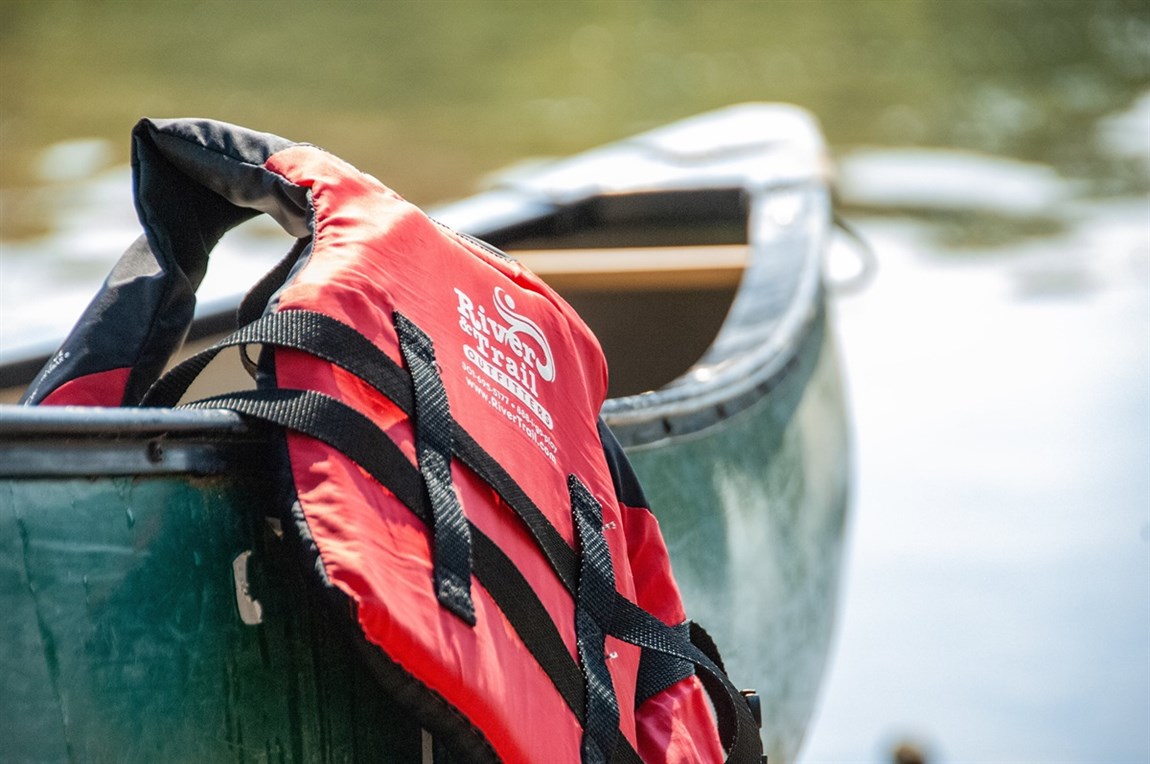 Picture of a Personal Floatation Device hanging on a canoe.  Photo