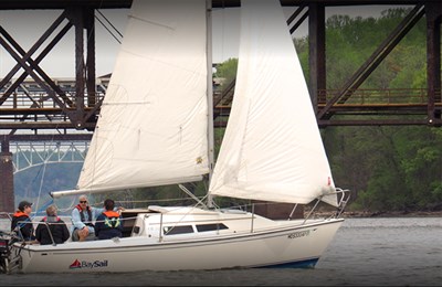 A group taking a sailing lesson on a white Bay Sail sailboat. Photo