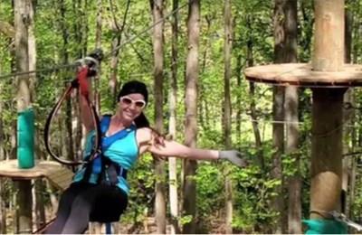 Young lady ziplining through the forest Photo