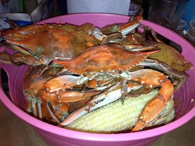 Basket of steamed crabs and white sweet corn Photo