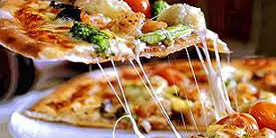 Slice of pizza being removed from a whole pizza Photo