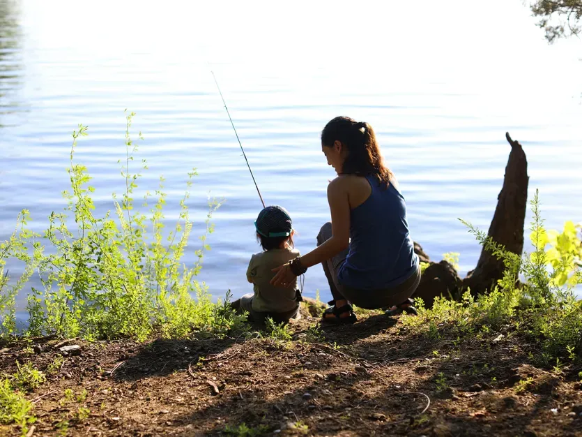 Mother and child fishing from a bank