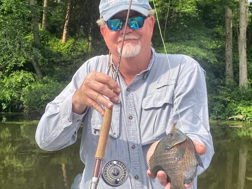 Fly fisherman holding a panfish