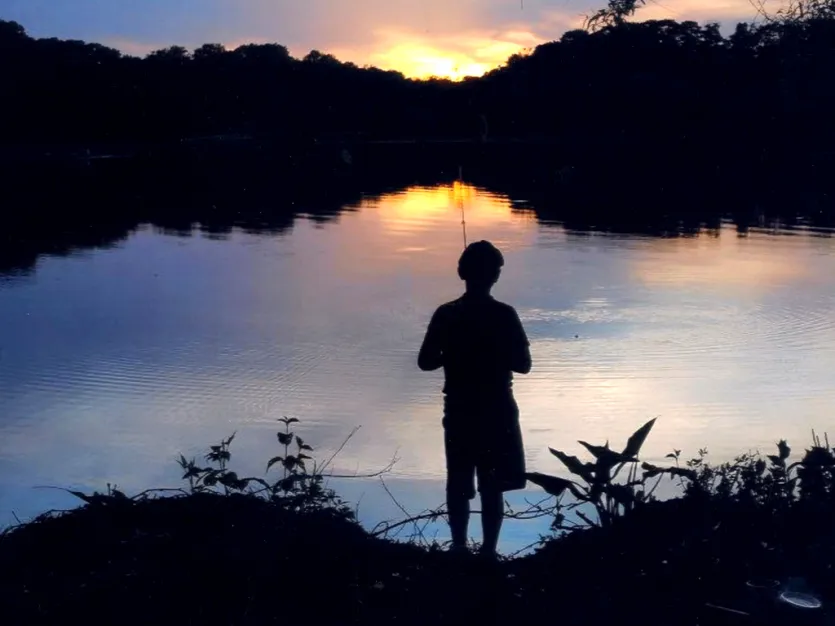 Young boy fishing during sunset