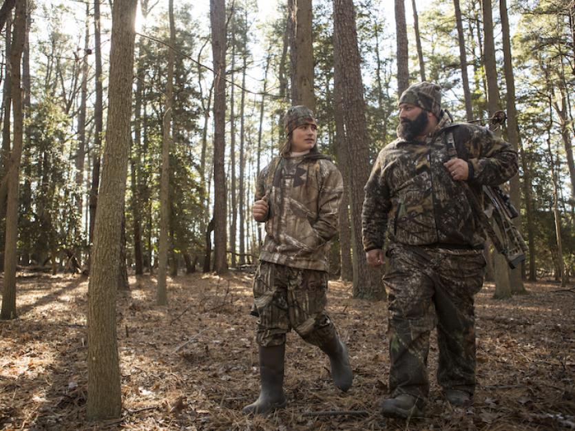Father and son hunting in the woods