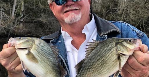 Fisherman holding two panfish