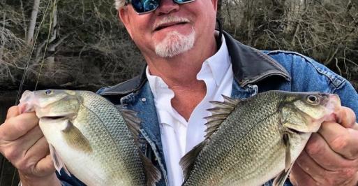 Fisherman holding two panfish