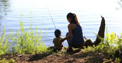 Mother and child fishing from a bank