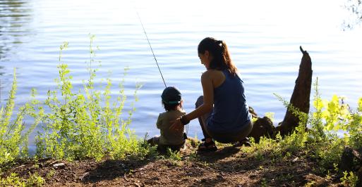 Mother and child fishing from a bank