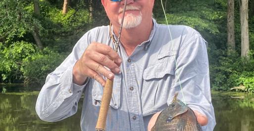 Fly fisherman holding a panfish