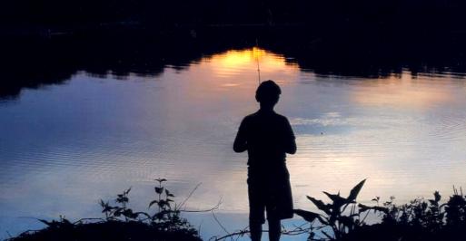 Young boy fishing during sunset