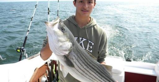 Fisherman holding a large striped bass
