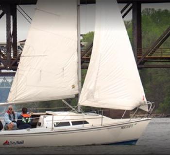 A group taking a sailing lesson on a white Bay Sail sailboat. Photo