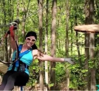 Young lady ziplining through the forest Photo