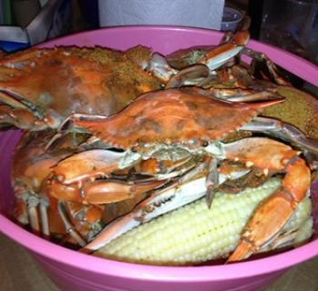 Basket of steamed crabs and white sweet corn Photo