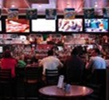 Inside the West End Grill bar area with TV screens showing sports. Photo