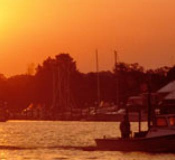 Photo of boats on the water at sunset Photo