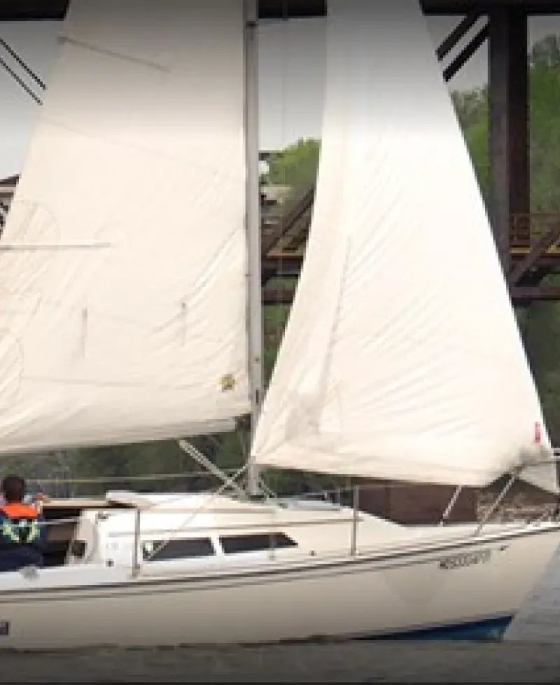 A group taking a sailing lesson on a white Bay Sail sailboat. Photo