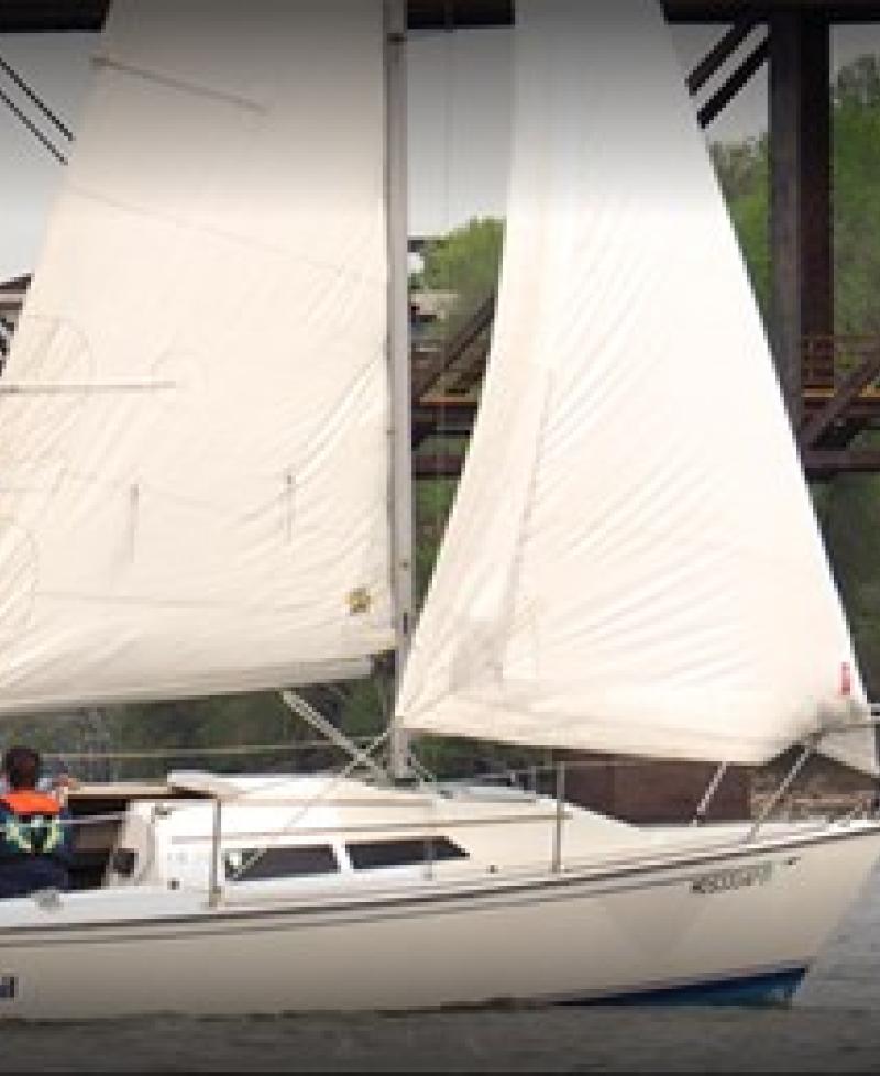 A group taking a sailing lesson on a white Bay Sail sailboat. Photo