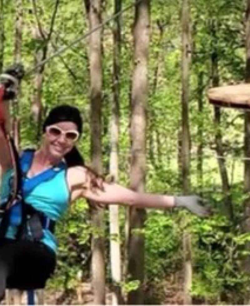 Young lady ziplining through the forest Photo