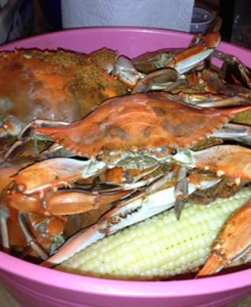 Basket of steamed crabs and white sweet corn Photo