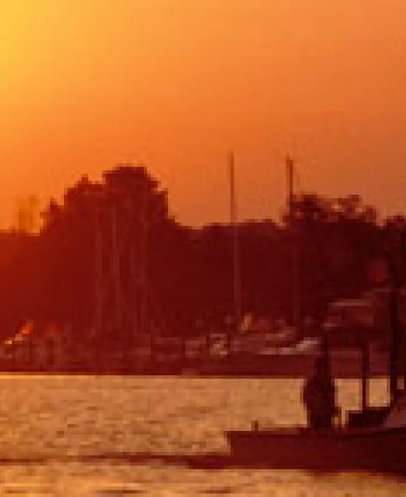 Photo of boats on the water at sunset Photo