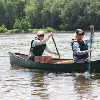 Two people in a canoe, paddling on the Potomac River.  Photo