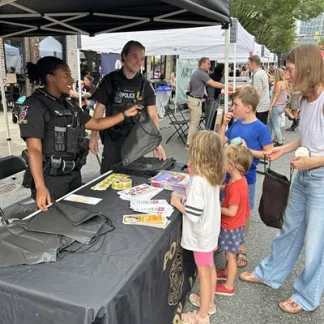 Local police officers provide goodies to 2025 National Night Out goers.  Photo