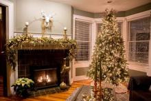 Inside one of the homes from a previous year on the tour. There is a fireplace and Christmas tree Photo