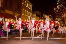 Dancers participating in the procession. The street is twinkling with holiday lights Photo