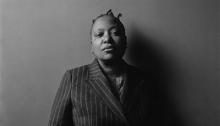 Meshell Ndegeocello black and white portrait in a pinstripe suit. Photo