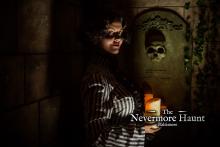 Victorian woman in the dark holding a candle in front a tomb  Photo