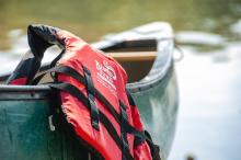 Picture of a Personal Floatation Device hanging on a canoe.  Photo