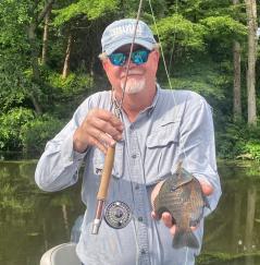 Fly fisherman holding a panfish